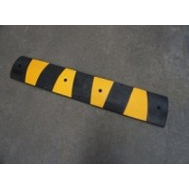 Black and yellow KOSEI speed bump photographed on the floor