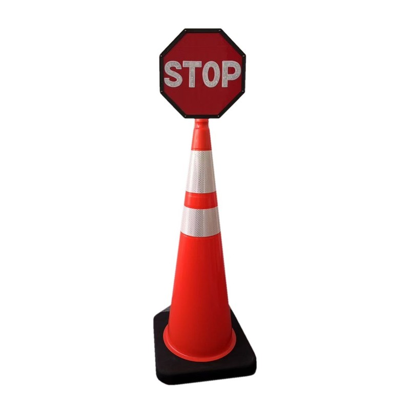 STOP sign mounted on top of an orange traffic cone